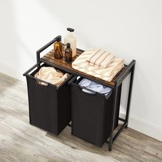 two black bins with towels and bottles on them