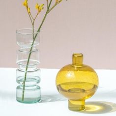 three glass vases with yellow flowers in them