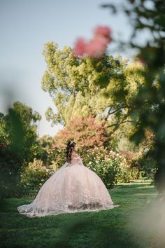 a woman in a wedding dress sitting on the grass