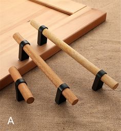 three pieces of wood with black handles on the floor next to a piece of wood