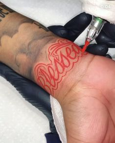 a person getting a tattoo done on their arm with a needle in the middle of it