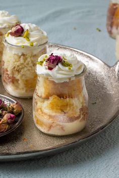 three desserts are sitting on a tray with flowers in the jar and one is half eaten