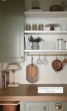 a kitchen counter with pots and pans hanging on the wall next to it's shelves