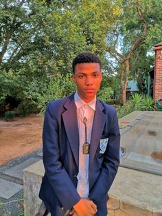 a young man in a suit and tie posing for the camera with his hands on his hips