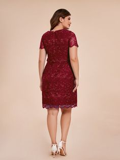 a woman in a red lace dress is looking back at the camera and she has her hands on her hips