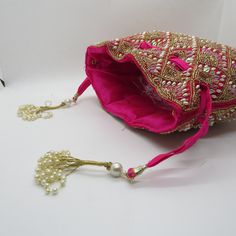 rani pink fabric pearl beaded the shining handbag drawstring purse potli bag for woman | indian wedding purse and potli gifting giveaways Designed with the heart, this beautiful Potli or batawa bag are eye catchy and made of premium material. Key Features: Embroidery art work This potli is good match with both Indian and western outfits and are superb for wedding and festive parties This would be best complement to your designer saree, lenhga or any other kind of dress This is the combination of Pink Shoulder Bag With Handwork For Party, Elegant Pink Handmade Potli Bag, Elegant Pink Shoulder Bag For Festivals, Elegant Pink Potli Bag For Festivals, Elegant Pink Shoulder Bag For Festive Occasions, Pink Festive Clutch, Party Pouch With Gota Work For Festivals, Elegant Pink Potli Bag For Gift, Festival Party Potli Bag