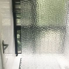 a bathroom with a glass shower door and tiled floor