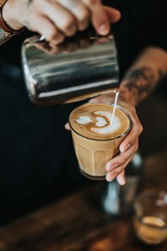 a person is pouring something into a cup