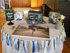 a table topped with pictures and flowers on top of a white table cloth covered table