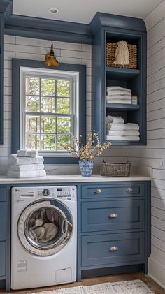 a washer and dryer in a room with blue cabinets