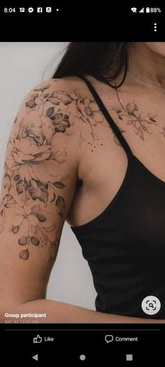 a woman wearing a black tank top with flowers on her arm and chest tattoo design