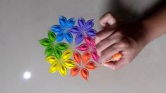 a person is holding some colorful paper flowers