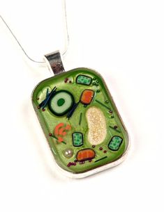 "LAST POSTING DATES These are the last dates that I can take orders for guaranteed Christmas arrival... UK: 19th December USA and all other international: 9th December Designed and handmade in Cambridge, UK.  Inspired by diagrams of plant cells, these pendants represent a 'slice of life', preserved forever in resin. Each piece is hand crafted using paints, polymer clay components, wire, glitter, microbeads, light reflective fibres and resin.  For a larger version of this pendant please see my ot Biology Teacher Gifts, Biology Jewelry, Plant Cells, Pharmacist Gift, Mini Plant, Science Teacher Gifts, Cambridge Uk, Science Jewelry, Plant Jewelry