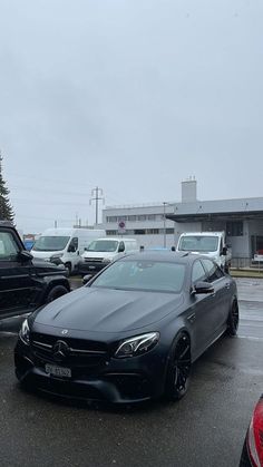 several cars parked in a parking lot on a rainy day