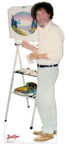 a man standing in front of a easel holding a paintbrush and an oil painting