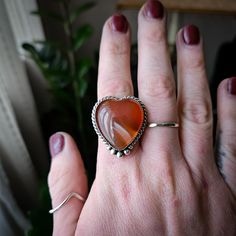 This funky carnelian heart is set in .925 sterling silver with hand forged sterling accents and will be finished in buyers size. The ring comes on a split sterling silver band. Please know your size and email or make note at checkout! All jewelry is handmade by Bree in Philadelphia, PA. Packaged with recycled products, all ready to ship items are processed in 3-5 days. Please allow a 10 day production period for all made to order pieces. Heart Shaped Carnelian Gemstone Jewelry, Heart-shaped Carnelian Gemstone Jewelry, Carnelian Heart Gemstone Jewelry, Carnelian Heart Shaped Gemstone Jewelry, Unique Sterling Silver Heart Ring, Handmade Bohemian Heart-shaped Rings, Bohemian Heart-shaped Rings For Gifts, Handmade Bohemian Heart Ring Gift, Bohemian Handmade Heart Ring Gift