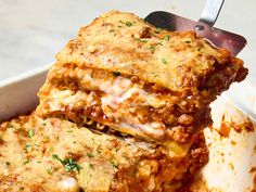 lasagna casserole in a white dish with a spatula on top