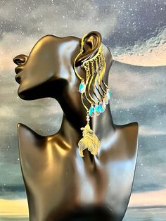 This enchanting water guardian ear cuff is sure to make a statement and bring out your inner magic! Gold ear cuff wrap is embellished with a light filigree gold fish charm and iridescent colorful glass drops dangling from wavy connectors and gold chains. This ear cuff is lightweight and perfect for adorning pierced and non-pierced Your jewelry is always wrapped in a jewelry bag and ready to be the perfect unique gift for yourself or someone you love! 💛 Fish Earrings Gold, Celestial Single Earring For Party, Whimsical Gold Earrings For Festival, Whimsical Gold Jewelry For Pierced Ears, Whimsical Brass Dangle Jewelry, Unique Dangle Cartilage Earrings, Gold Dangle Pierced Ear Cuff, Unique Adjustable Gold Clip-on Earrings, Fantasy Dangle Earrings For Festival