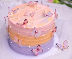 there is a multi layer cake with butterflies on it