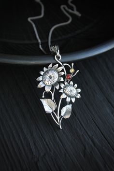 ITEM DESCRIPTION: The size H 3 cm x W 5 cm Weight - 5 g. You can buy it with a silver chain or without it. I made this Sunflower pendant of sterling silver 925, garnet, and citrine. I used these warm stones to make this summer charm brighter and more joyful. These amazing flowers are full of vitality and energy. This is a piece of really modern and detailed jewelry. This handmade necklace will come to you in a gift box - ready for gifting. The parcel will be sent during 1-2 days after payment. D Sterling Silver Flower Pendant With Oxidized Finish, Engraved Sterling Silver Flower Pendant Jewelry, Unique Sterling Silver Necklace Gift For Her, Spiritual Oxidized Flower Pendant Jewelry, Nature-inspired Oxidized Pendant Necklace, Sterling Silver Pendant Necklace For Her, Sterling Silver Pendant With Oxidized Finish, Sterling Silver Nature-inspired Necklace For Anniversary, Sterling Silver Flower Jewelry For Jewelry Making