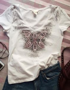 This is a hand painted t shirt, featuring an original design of a Celtic knot forming a butterfly. The butterfly has a burgundy outline that gives this mostly black and white tee a subtle hint of color. The grunge background is unique to every shirt, as it is hand-printed. #HandPaintedTshirts, #OriginalArt, #PersonalizedTshirt, #PersonalizedGiftsWomen Painted T Shirt, H&m Brand, Tshirt Knot, Butterfly T Shirt, Tshirt Custom, Tee Designs, Black And White Tees, Business Board, Infinity Knot