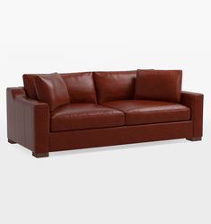 a brown leather couch sitting on top of a white floor