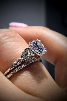 a woman's hand holding an engagement ring