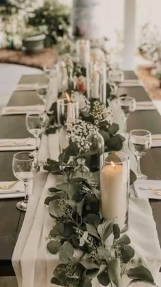 a long table is set with candles and greenery for an elegant dinner or party