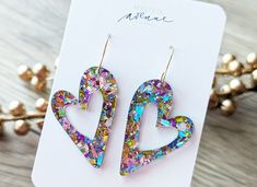 Pastel Chunky Confetti, Mod Heart Glitter Earrings  These glitter mod heart earrings are the perfect addition to your Valentine's day outfit! Acrylic Earrings with a stainless steel hook.  The exact look of the glitter will vary from earring to earring as we cut them from one large sheet of acrylic.  The photos are a sample and the pair you receive will be very similar in look. Heart Earrings For Mother's Day Party, Heart-shaped Earrings For Mother's Day Party, Mother's Day Heart Earrings For Party, Trendy Double Heart Earrings For Party, Mother's Day Double Heart Earrings For Party, Glitter Earrings For Valentine's Day Party, Trendy Party Heart Earrings With Heart Charm, Matching Heart Earrings For Valentine's Day Party, Party Open Heart Earrings