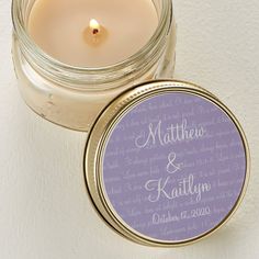 a candle with a label on it sitting next to a white wall