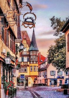 an old european town with cobblestone streets and colorful buildings on either side of the street