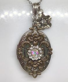 This stunning vintage inspired photo locket is a true treasure that captures the essence of old-world charm. Adorned with delicate rhinestones and bronze/silver charm, this antique inspired photo locket exudes timeless elegance and sophistication. It doubles as a beautiful bridal necklace, making it the perfect accessory for any bride on her special day. Whether you're looking for a thoughtful birthday present or a romantic gift for your wife, this exquisite locket is sure to be cherished for ye Bronze Vintage Charm Jewelry For Anniversary, Bronze Jewelry With Vintage Charm For Anniversary, Metal Pendant Locket Necklace For Wedding, Vintage Oval Jeweled Necklaces, Vintage Jeweled Oval Necklace, Antique Silver Jeweled Jewelry, Vintage Oval Jeweled Necklace, Antique Jeweled Silver Jewelry, Antique Jeweled Jewelry For Anniversary