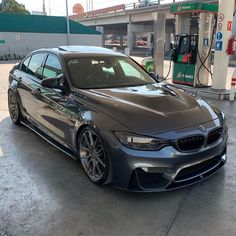 a grey car is parked in front of a gas station