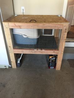 a wooden table sitting in the middle of a room next to a wall with a bucket on it