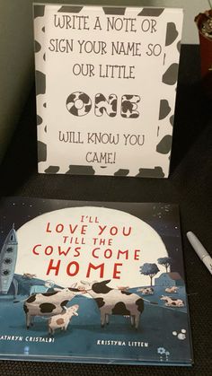 two children's books are sitting on a table next to a sign that says, write a note or sign your name so our little cow will know you came