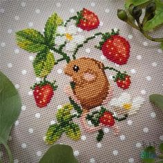 a cross - stitch picture of a hamster with strawberries and daisies