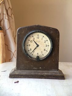 an old clock sitting on top of a table