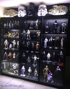 star wars action figures on display in a room with tile flooring and black shelves