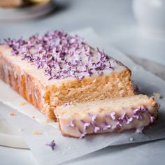 a piece of cake with purple sprinkles sitting on top of white paper