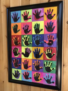 colorful handprints are displayed in a black frame