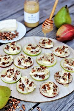 apples, nuts and honey are arranged on a plate