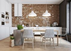 an open kitchen and dining area with brick wall, white cabinets and wooden flooring