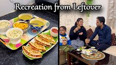 a family sitting on a couch with food and drinks in front of them, while the child is eating