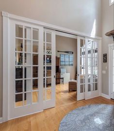 an open living room with french doors and hardwood floors