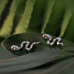 The snake is one of the oldest and most widespread mythological symbols, a symbol of transformation, rebirth and immortality. Crafted in sterling silver, each earring is set with glittering white stones as skin and decorated with red stones to add its spark. If you are interested in snake jewelry, just add this pair of earring to your jewelrybox.Carat Weight: 0.612 ctStone Size: 1,1.2,1.8,1.2,3*1.5 mmStone Type: Jeulia® StoneNumber of Stones: 29 Stone Shape: Round, MarquiseStone Color: Diamond W Silver Snake-shaped Pierced Earrings, Sterling Silver Snake-shaped White Gold Jewelry, Silver Snake Shape Earrings, Sterling Silver White Gold Snake-shaped Jewelry, Sterling Silver Snake Shape Jewelry In White Gold, Silver Snake-shaped Earrings, Silver Snake-shaped Earrings For Pierced Ears, Silver Snake-shaped Single Earring, Snake-shaped Single Earring As Gift