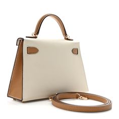 This is an authentic HERMES Epsom Horseshoe Mini Kelly Sellier 20 in Craie and Biscuit. This stunning handbag is crafted in stamped epsom calfskin leather in ivory and tan. A single rolled leather top handle is secured with gold plated hardware and an optional leather shoulder strap is included. The traditional Kelly turn lock secures the small flap. The interior features a matching chevre goatskin leather with a single flat pocket. Hermes Crossbody Bag, Kelly Sellier, Mini Kelly, Plastic Stickers, Hermes Bags, Bag Straps, Leather Top, Top Handle, Calf Skin