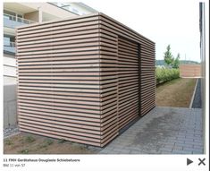 an image of a building made out of wooden slats on the side of a road