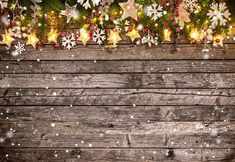 an old wooden background with christmas decorations and lights on it, including snowflakes