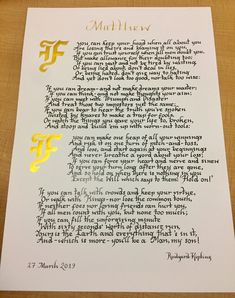 a letter written in gold foil on top of a piece of paper with writing underneath it