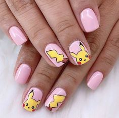 a woman's hand with pink and yellow nail polishes decorated with pikachu